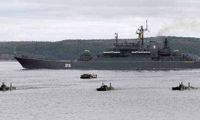 A Russian warship and amphibious military vehicles move during a naval parade rehearsal at the port of Severomorsk in the Barents sea