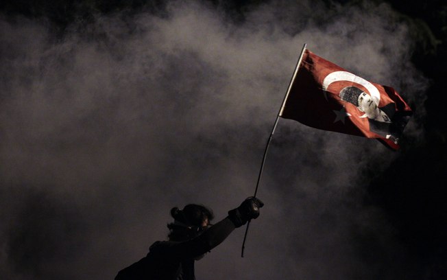 Manifestante segura bandeira da Turquia decorada com a imagem do fundador da Turquia Mustafa Kemal Ataturk, durante protesto na praça Taksim em Istambul (3/6) foto: AP