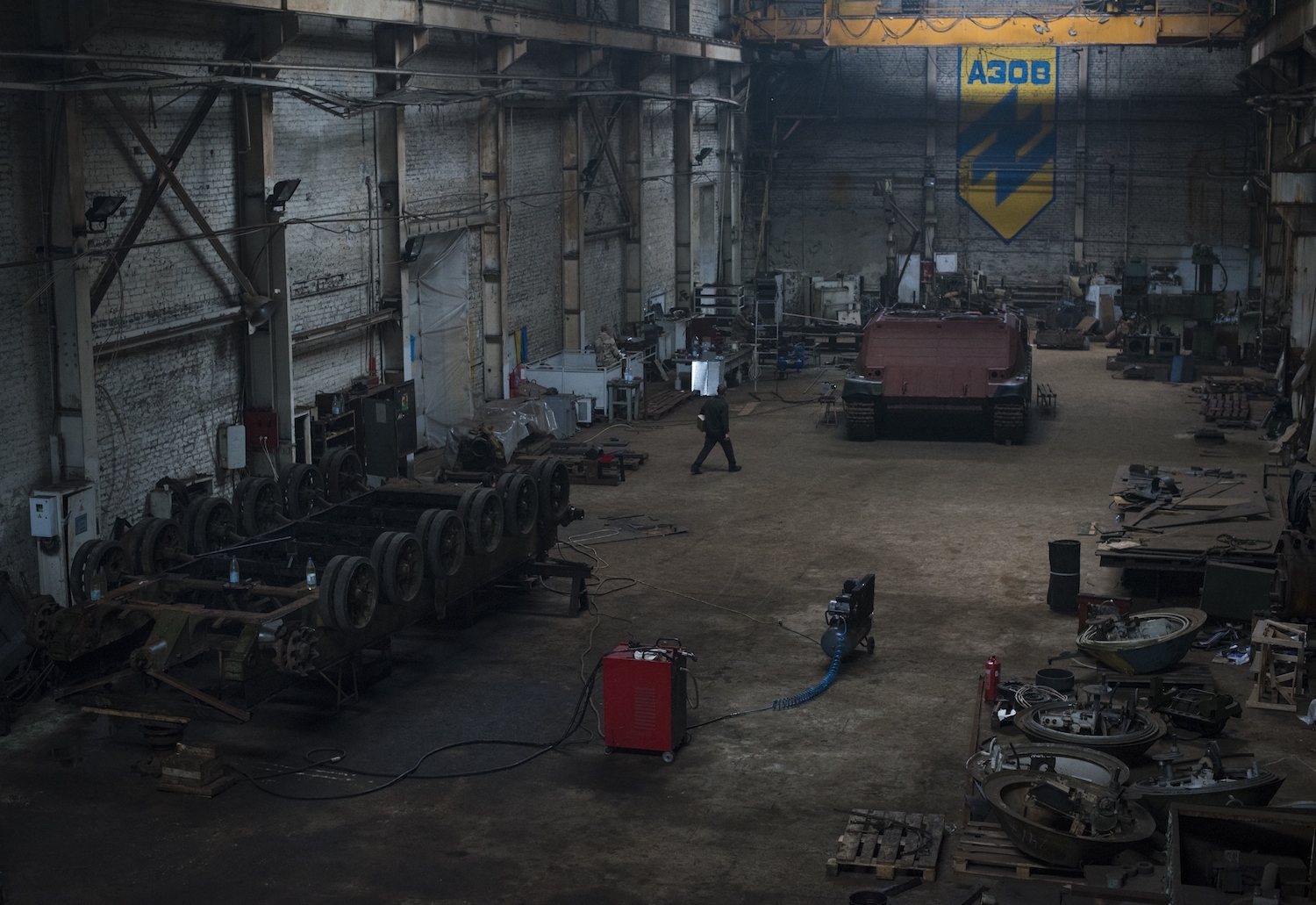 Panorama da garagem do Grupo de Engenharia Azov, 9 de setembro de 2015, Kiev, Ucrânia. À esquerda, um chassi invertido de um tanque se encontra em processo de desmontagem, antes de ser reconstruído como um novo veículo, muito semelhante ao “Azovette” (canto superior direito), que passou por construção similar. Créditos: Pete Kiehart 