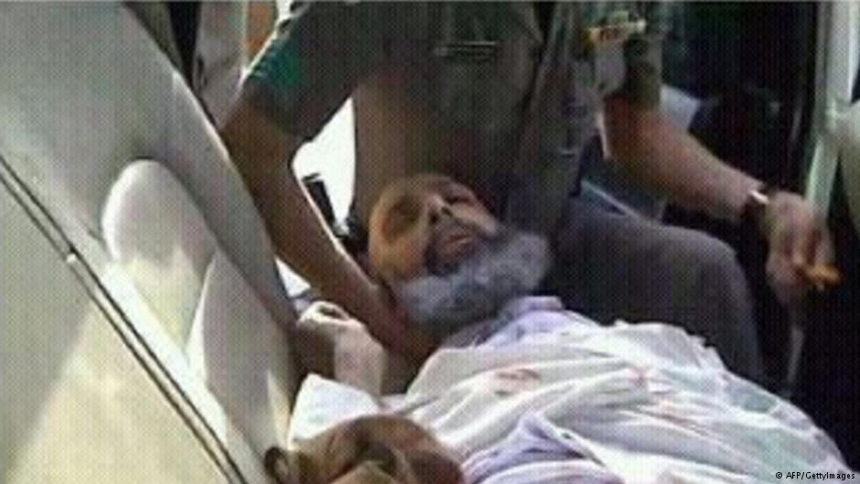 Nimr Baqir al-Nimr deitado no banco traveseiro de uma viatura policial durante sua detenção, em julho de 2012